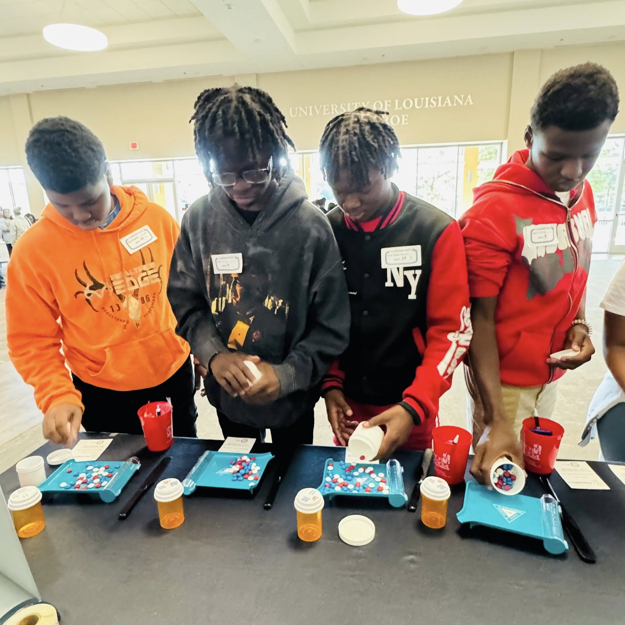 Four boys counting out pills.